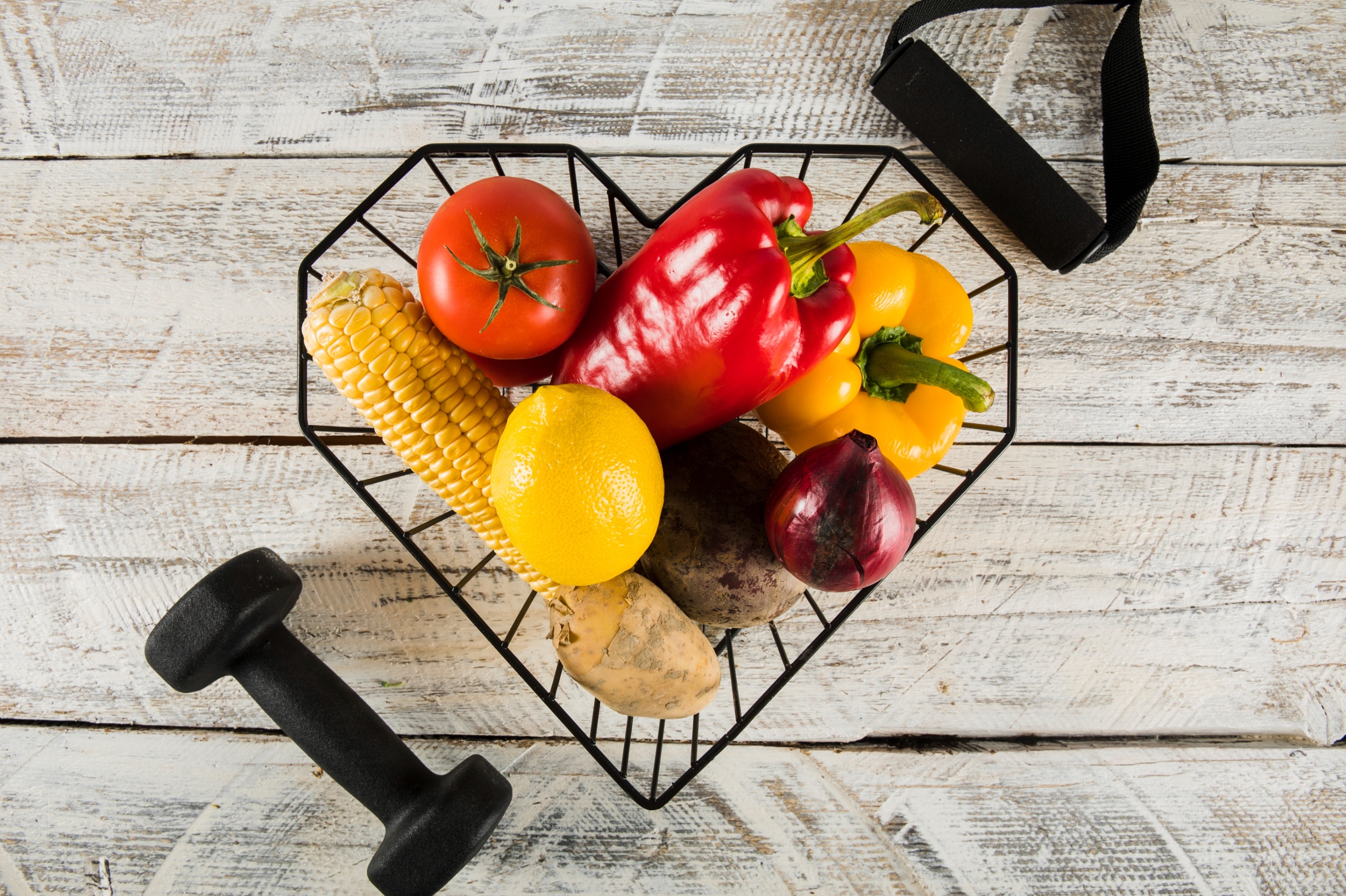 Elevated view colorful raw vegetables with fitness equipments wooden background (1)