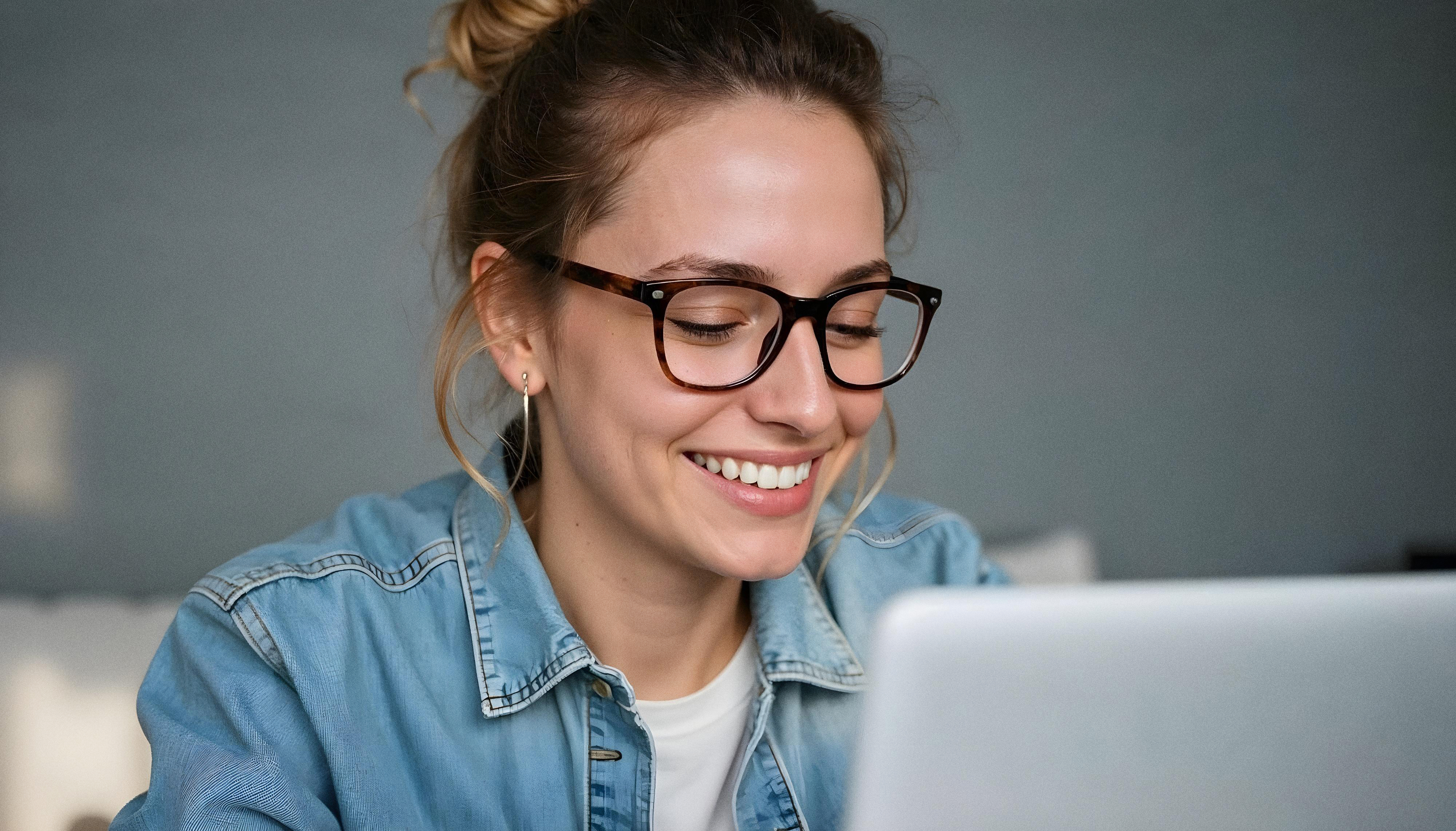 Woman working laptop smiling relaxed natural light setup
